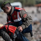 Un policía turco traslada el cuerpo sin vida de un niño tras otro naufragio en el Egeo.-AFP / OZAN KOSE