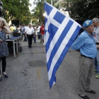 Un simpatizante del partido conservador de Nueva Democracia sale a la calle vestido de azul y con la bandera griega, a 20 días de las elecciones generales.-EFE / ALEXANDROS VLACHOS