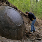 Suad Keserovic limpia la esfera de piedra en Podubravije, cerca de Zavidovici (Bosnia), el 11 de abril.-REUTERS / DADO RUVIC