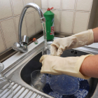 Una persona friega los cacharros en la cocina de su vivienda.-ISRAEL L. MURILLO