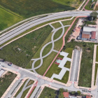 En esta imagen aérea se puede observar que las obras se pararon a mitad de un vial y junto a la glorieta los almacenes de materiales de construcción.-ECB