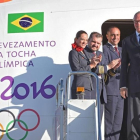 El presidente del Comite Olímpico Brasileño, Carlos Arthur Nuzman, transporta la linterna con el fuego olímpico a su llegada a Brasilia.-AFP / EVARISTO SA