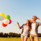 Una pareja riendo con globos.-123RF