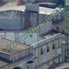 Vista aérea del brazo de la grúa caído sobre el tejado de una vivienda anexa a la obra.-ISRAEL L. MURILLO