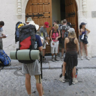 Varios peregrinos esperan a la puerta del albergue del Paseo de los Cubos un día de verano.-RAÚL G. OCHOA