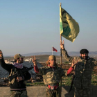 Milicianos kurdos con una bandera del líder del PKK, Abdulá Ocalán, en las cercanías de la ciudad siria de Alepo.-AP / MURSEL COBAN