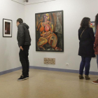 Un chico mira las fotos de Vitorino y unas chicas, los dibujos de Cinta Aller, con la pintura de Rachel Merino en medio.-Santi Otero