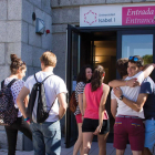 Un grupo de alumnos de la universidad se saludan en la entrada del edificio.-ECB