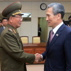 El ministro surcoreano de Unificación, Kim Kwan-jin, a la derecha, da la mano a Hwang Pyong So, responsable norcoreano, tras alcanzar el acuerdo para rebajar la tensión.-AP