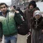 Una familia siria espera a ser evacuada de Alepo.-AFP