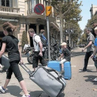 Turistas con maletas rumbo a su alojamiento recorren el paseo de Gràcia.-Foto:   JOAN CORTADELLAS