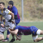 Todd Doolan es placado por un jugador del FC Barcelona en el inicio del choque disputado ayer en la Teixonera.-AREA 11