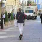 Una mujer circula en patinete por la calle La Moneda.