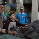 Un niño sirio es consolado mientras llora junto al cuerpo de su hermano pequeño que murió en el ataque aéreo del régimen de Bashar al Asad al hospital de Al Quds.-AFP / KARAM AL-MASRI