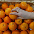 Una persona coge una naranja en un supermercado.-DANNY CAMINAL (ARCHIVO)