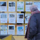 Un hombre mira los anuncios de venta de viviendas de una inmobiliaria.-ISRAEL L. MURILLO