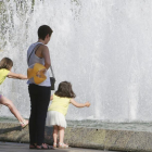 Dos niñas se refrescan junto a su madre en la fuente ubicada junto al Museo de la Evolución.-RAÚL G. OCHOA