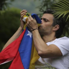 Leopoldo López besa la bandera venezolana tras salir de prisión, el pasado 8 de julio-AP / ARIANA CUBILLOS