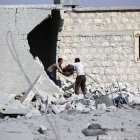 Civiles sacan sus pertenencias de su vivienda bombardeada en una localidad de los alrededores de Alepo.-KHALIL ASHAWI / REUTERS