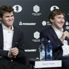 El noruego Carlsen (izquierda) sonríe mientras el derrotado ajedrecista ruso Karjakin habla en la rueda de prensa posterior a la partida definitiva.-JUSTIN LANE / EFE