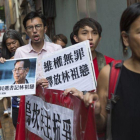 Varios seguidores del alcalde de la localidad meriodional de Wukan, Lin Zuluan, sostienen pancartas y protestan de camino a la oficina china Liaison en Hong Kong.-JEROME FAVRE / EFE