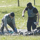 Policías franceses examinan las armas de uno de los zulos de ETA.-GUILLAUME HORCAJUELO