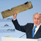 Netanyahu muestra el trozo del supuesto drone iraní que Israel asegura derribó la semana pasada mientras sobrevolaba su territorio.-AFP/ LENNART PREISS