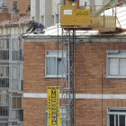 Un trabajador, sobre el tejado de una vivienda.-ISRAEL L. MURILLO