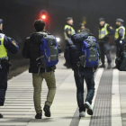 Policías suecos acompañan a dos refugiados en la estación de tren de Hyllie, en Malmo.-REUTERS / JOHAN NILSSON