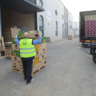 Varios voluntarios descargan cajas de productos.-ISRAEL L. MURILLO