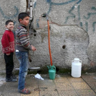 Varios niños hacen acopio de agua en la ciudad siria de Duma, cerca de Damasco.-REUTERS / BASSAM KHABIEH