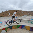 Un joven con una bicicleta en el parque de San Isidro. A partir de octubre se sembrarán las laderas.-ISRAEL L. MURILLO
