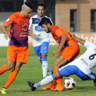 Torres y Manchado pugnan por un balón con un jugador del Almazán-Santi Otero