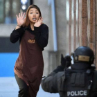 Una empleada del café sale corriendo del local, este lunes en Sídney.-Foto: AFP / SAEED KHAN