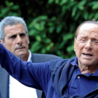 Silvio Berlusconi saluda a sus seguidores al salir del hospital.-STRINGER