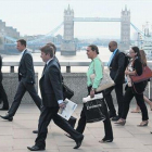 Empleados de la City londinense atraviesan el puente de Londres para dirigirse al trabajo, el pasado agosto.-REUTERS / LUKE MCGREGOR