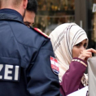 Un policía ordena a una mujer musulmana que se retire el velo en Austria.-AFP