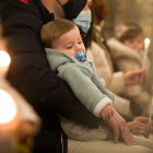Un niño recostado sobre su padre durante la Misa de la Luz. TOMÁS ALONSO.