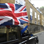 Un motorista con una bandera británica en el centro de Londres.-TOBY MELVILLE / REUTERS