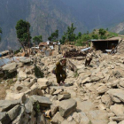 Nepalís caminan entre escombros de casas en la localidad de Ungul, a 60 kilómetros de Katmandú, el lunes.-Foto: AFP / PRAKASH MATHEMA