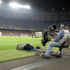 Un reportero gráfico grabando un partido de fútbol.-