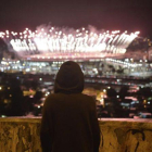 Un niño observa desde el Morro da Mangueira los fuegos artificiales de Maracaná durante la ceremonia de clausura de los Juegos, este domingo.-EFE / FABIO TEIXEIRA