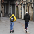 Tres jóvenes en patinete eléctrico por una céntrica calle de Burgos. RAÚL G. OCHOA