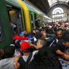 Los cientos de inmigrantes que han esperado durante dos días la reapertura de la estación de Keleti suben masivamente al primer tren.-REUTERS