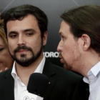 Alberto Garzón y Pablo Iglesias, con la presidenta andaluza, Susana Díaz, detrás, anoche, en un acto en el Palacio de Cibeles de Madrid.-EFE / JAVIER LIZÓN