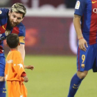 Messi indica a Murtaza, el niño afgano, que debe abandonar el césped en Doha.-AFP / KARIM JAAFAR
