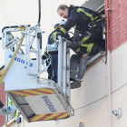 Uno de los bomberos accede a la ventana mientras otro conversa con el hombre.-ISRAEL L. MURILLO
