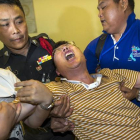 Un ciudadano chino que perdió a su mujer y a su hija en el atentado llora desconsolado en el Instituto de Medicina Forense de Bangkok.-Foto:   REUTERS / ATHIT PERAWONGMETHA