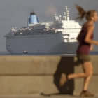 Una mujer corre por el Malecón mientras el crucero Thomson Dream llega a La Habana, el 19 de marzo.-Foto:   AP / DESMOND BOYLAN