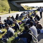 Un grupo de refugiados descansan en medio de una autopista en el sur de Dinamarca.-AP / ERNST VAN NORDE